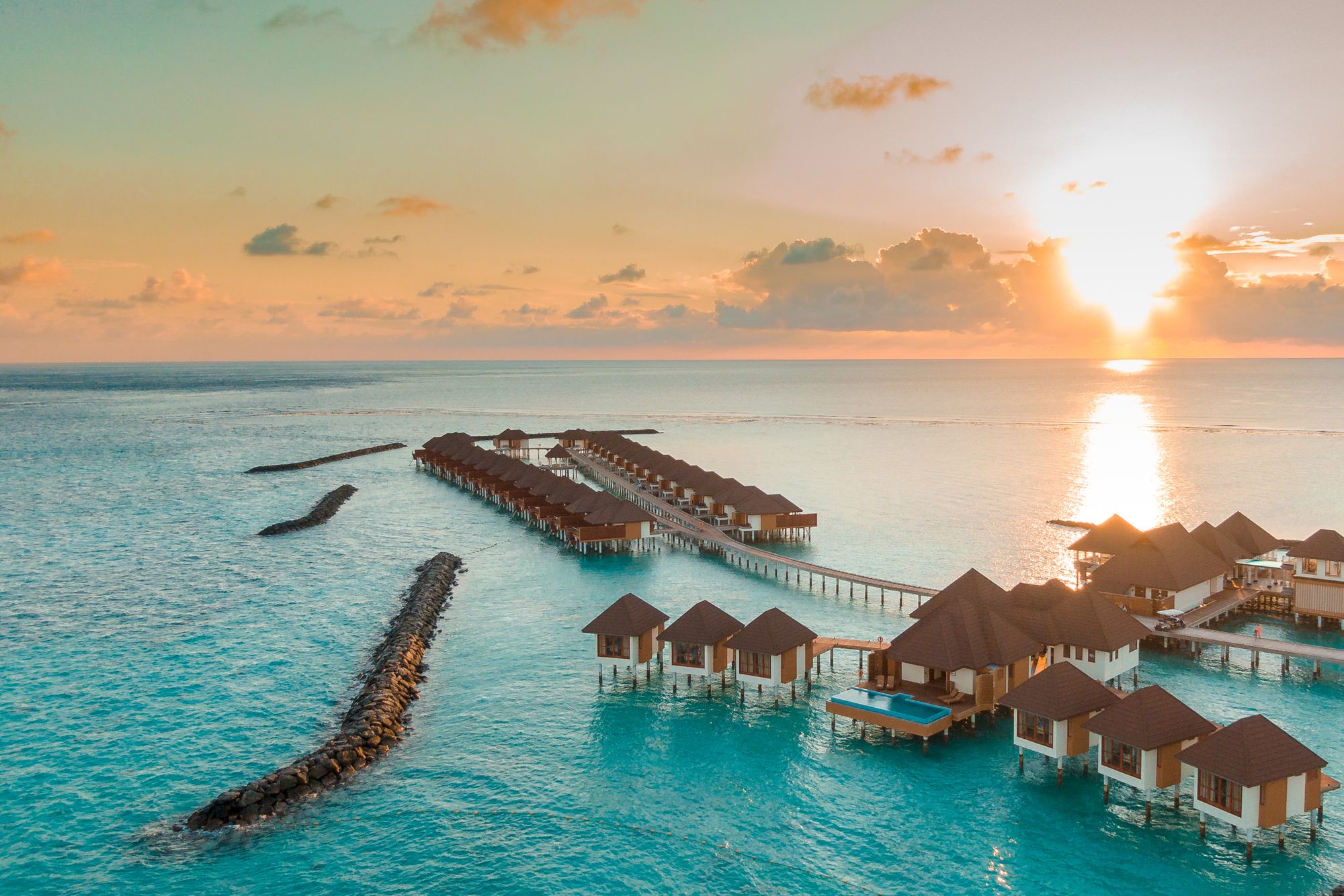 Overwater villas at golden sunset in the Maldives